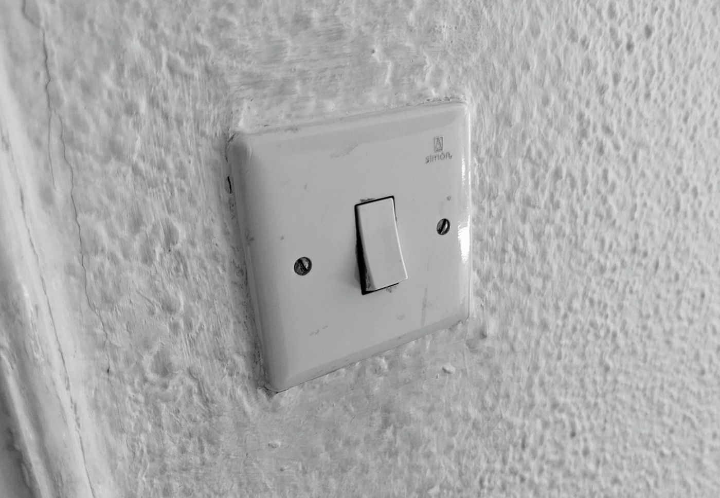 Eine weiße Wand mit einem alten Druckknopfschalter